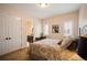 Cozy bedroom featuring a comfortable bed, desk, and an ensuite bathroom through an arched doorway at 2117 S Juniper St, Lakewood, CO 80228
