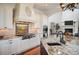 Gourmet kitchen with stainless steel appliances, custom range hood, and island seating at 2117 S Juniper St, Lakewood, CO 80228