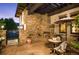 Cozy outdoor patio with a stone fireplace, comfortable seating, and privacy landscaping at 2117 S Juniper St, Lakewood, CO 80228
