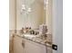 Chic powder room with granite countertop, decorative mirror, and sconces adding a touch of elegance at 2117 S Juniper St, Lakewood, CO 80228