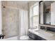 Bathroom featuring a shower over the tub with white and patterned tiles, and a modern vanity at 619 S High St, Denver, CO 80209