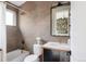 Bathroom features a bathtub and shower, a white toilet, and a sink with a mirror above at 619 S High St, Denver, CO 80209