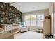 Charming Bedroom features a crib and a cozy chair with beautiful wallpaper and ample natural light at 619 S High St, Denver, CO 80209