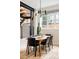 Bright dining room boasts an industrial staircase, modern chandelier, and natural light from the large window at 619 S High St, Denver, CO 80209