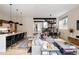 Open-concept living space showcasing a modern kitchen with island seating and comfortable living area with stairs at 619 S High St, Denver, CO 80209