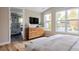 Serene main bedroom with ensuite bathroom, a dresser with TV and natural light from large windows at 619 S High St, Denver, CO 80209