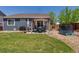 This back yard includes a well-kept lawn, privacy fence, pergola-covered patio, and trampoline at 2670 E 136Th Pl, Thornton, CO 80602