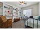 Comfortable bedroom with built-in shelving, a cozy chair, and a neutral color palette at 2670 E 136Th Pl, Thornton, CO 80602