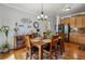 Dining area adjacent to the kitchen featuring hardwood floors, stainless steel appliances, and warm lighting at 2670 E 136Th Pl, Thornton, CO 80602