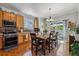 Dining area features hardwood floors, stainless steel appliances, a sliding door to the backyard, and warm lighting at 2670 E 136Th Pl, Thornton, CO 80602