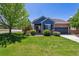 Charming blue and brick home with a well-manicured lawn, mature trees, and inviting curb appeal at 2670 E 136Th Pl, Thornton, CO 80602