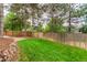 Backyard featuring a lush lawn, privacy fence, mature trees and beautiful landscaping at 8588 S Woody Way, Highlands Ranch, CO 80126