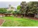 The spacious backyard features mature trees, a wood fence, and a charming upper-level deck at 8588 S Woody Way, Highlands Ranch, CO 80126