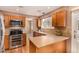 Well-lit kitchen featuring wooden cabinets, stainless steel appliances, and a view to the living room at 8588 S Woody Way, Highlands Ranch, CO 80126
