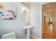 Powder room with pedestal sink, updated lighting, wainscotting, and a colorful art piece at 474 W Spruce St, Louisville, CO 80027