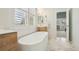Clean and bright bathroom features a freestanding tub, wooden vanities, and white tile walls at 474 W Spruce St, Louisville, CO 80027