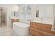 Bright bathroom features a freestanding tub, wood vanities, and marble tile flooring at 474 W Spruce St, Louisville, CO 80027