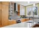 Modern kitchen featuring frosted glass cabinetry, stainless steel appliances and hood, quartz countertops and backsplash at 474 W Spruce St, Louisville, CO 80027