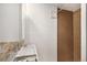 Bathroom with a white sink and cabinet, contrasted by the warmth of the brown tiled shower at 1380 S Fillmore St, Denver, CO 80210