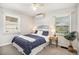 Cozy bedroom featuring a ceiling fan, two windows and stylish blue bedding and bedside table at 1380 S Fillmore St, Denver, CO 80210