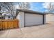 Detached garage with white door, neutral stucco, and a wooden fence offering secure parking and storage at 1380 S Fillmore St, Denver, CO 80210