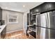 Compact kitchen with dark cabinetry, stainless steel appliances, and hardwood floors at 1380 S Fillmore St, Denver, CO 80210