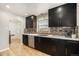 Modern kitchen with dark cabinetry, stainless steel appliances, and mosaic backsplash at 1380 S Fillmore St, Denver, CO 80210