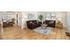 Bright living room with hardwood floors, leather couches, and large windows allowing natural light to stream in at 1380 S Fillmore St, Denver, CO 80210