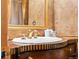 Close up of a bathroom vanity with gold fixtures and a white sink at 9061 N Rex Ln, Conifer, CO 80433