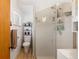 Bathroom featuring a glass shower, wood-style floors, decorative shelving and a white toilet and vanity at 9061 N Rex Ln, Conifer, CO 80433