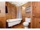 Bathroom with vintage-style clawfoot tub and wood paneling details at 9061 N Rex Ln, Conifer, CO 80433
