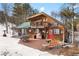 Charming cabin features a wooden deck and red door, surrounded by trees and a hint of snow at 9061 N Rex Ln, Conifer, CO 80433