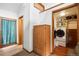 Hallway leading to a laundry room with front-loading washer and dryer, next to storage at 9061 N Rex Ln, Conifer, CO 80433