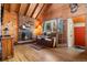 Cozy living room with a stone fireplace, wood floors, and a view of the outdoors at 9061 N Rex Ln, Conifer, CO 80433