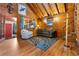 Inviting living room with wooden walls, high ceilings, comfortable seating, and a decorative rug at 9061 N Rex Ln, Conifer, CO 80433