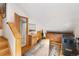 An open and unique room with wood floors and walls, a bathroom and other rooms beyond, and cozy, warm lighting at 9061 N Rex Ln, Conifer, CO 80433