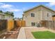 A private backyard features an artificial lawn, gravel, concrete paths, mulch beds, and a wood fence at 3470 W Walsh Pl, Denver, CO 80219