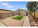A private backyard features artificial grass, a graveled area, a concrete path, and a tall wooden fence at 3470 W Walsh Pl, Denver, CO 80219
