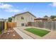 A cozy backyard features an artificial lawn, mulch beds, a gravel area, and a wood fence at 3470 W Walsh Pl, Denver, CO 80219