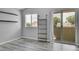 Well-lit bedroom with sliding glass doors, shelves, and gray wood flooring at 3470 W Walsh Pl, Denver, CO 80219