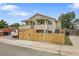 Inviting two-story home with a private balcony, fenced yard, and convenient street access, set against a blue sky backdrop at 3470 W Walsh Pl, Denver, CO 80219