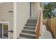 Exterior steps leading to the home's entrance with light siding and a wooden railing at 3470 W Walsh Pl, Denver, CO 80219