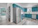 Modern kitchen with vibrant blue cabinets, stainless appliances, and in-unit washer/dryer at 3470 W Walsh Pl, Denver, CO 80219