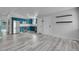 Bright, open living room featuring gray wood-look flooring and a kitchen view at 3470 W Walsh Pl, Denver, CO 80219
