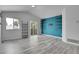 Bright living area with gray wood-look floors, a sliding door and shelving unit at 3470 W Walsh Pl, Denver, CO 80219