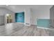 Open-concept living room with gray wood-look flooring, leading to an outdoor balcony at 3470 W Walsh Pl, Denver, CO 80219