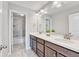 A bathroom with double sinks, dark wood cabinets, and a gray tile shower behind a door at 10887 Endeavor Dr, Parker, CO 80134
