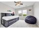 A bedroom with a window, a ceiling fan, a bed with drawers, and a beanbag chair at 10887 Endeavor Dr, Parker, CO 80134