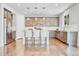 An open kitchen featuring wooden floors, a large island with seating, and stainless steel appliances at 10887 Endeavor Dr, Parker, CO 80134