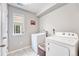 A tidy laundry room with gray tile floors, a window, and a laundry hamper at 10887 Endeavor Dr, Parker, CO 80134